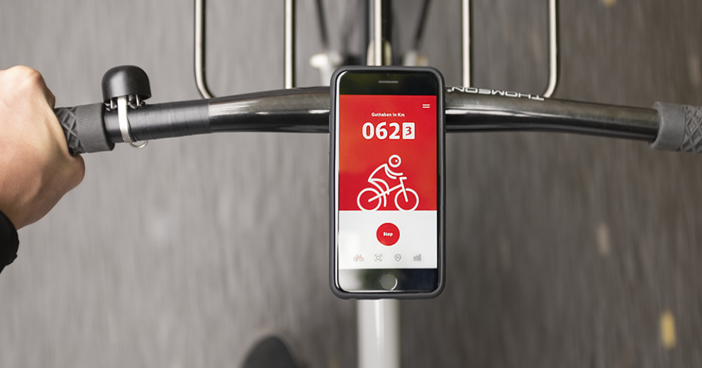 Blick auf ein am Fahrrad befestigtes Smartphone mit der geöffnete App von DB Rad+