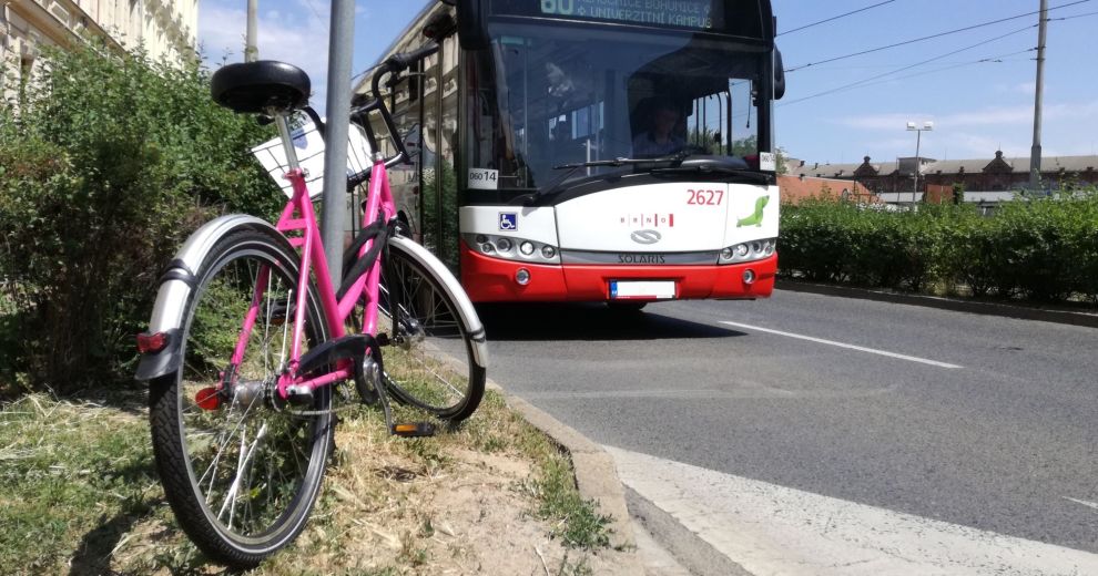 Ein Fahrrad steht an einer Straße, ein Bus im Hintergrund