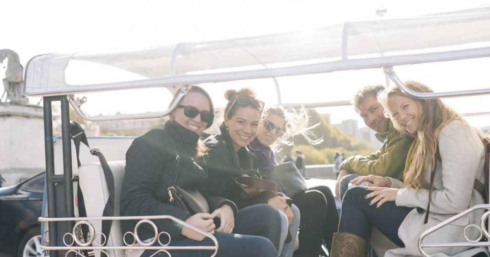 Eine Gruppe von Freunden posiert in einer Rikscha für ein Foto.