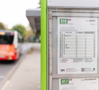 Ein Fahrplan und im Hintergrund ein Bus