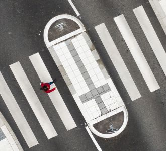 Eine Frau überquert die Straße auf einem Zebrastreifen.