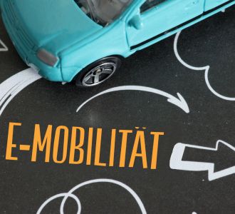 Ein Wagen und ein Pfeil der in Richtung e-Mobilität zeigt.